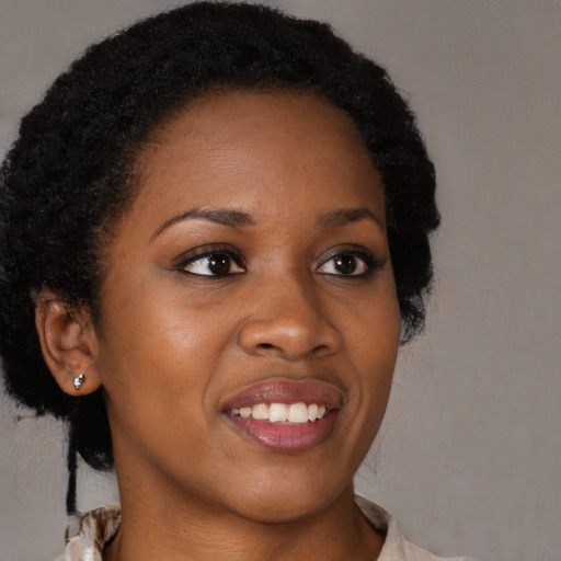 Joyful black young-adult female with long  brown hair and brown eyes
