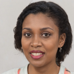 Joyful black young-adult female with long  brown hair and brown eyes