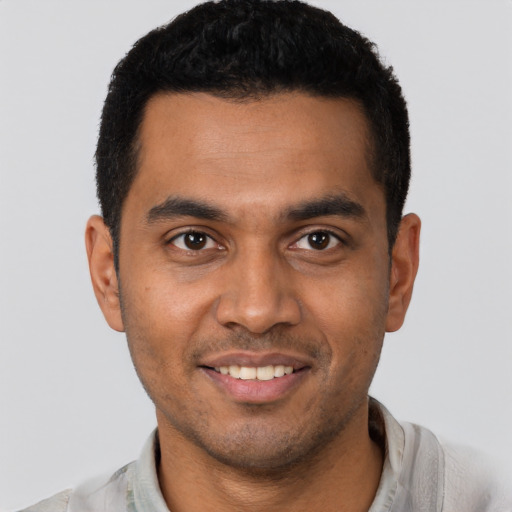 Joyful latino young-adult male with short  brown hair and brown eyes