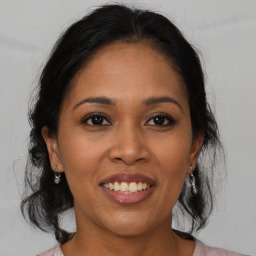 Joyful latino adult female with medium  brown hair and brown eyes