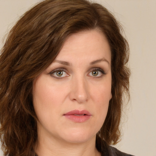 Joyful white young-adult female with long  brown hair and green eyes