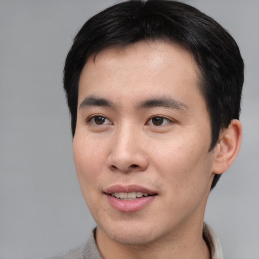 Joyful asian young-adult male with short  brown hair and brown eyes