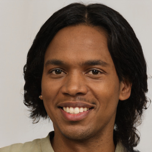 Joyful black young-adult male with medium  black hair and brown eyes