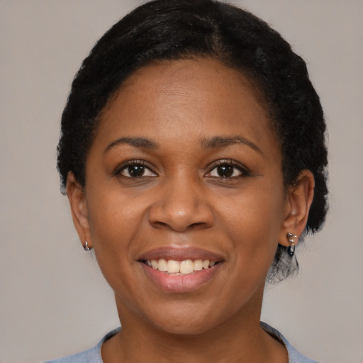 Joyful black adult female with short  black hair and brown eyes