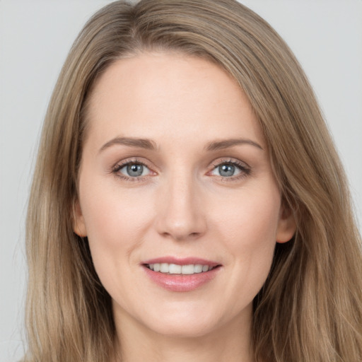 Joyful white young-adult female with long  brown hair and grey eyes