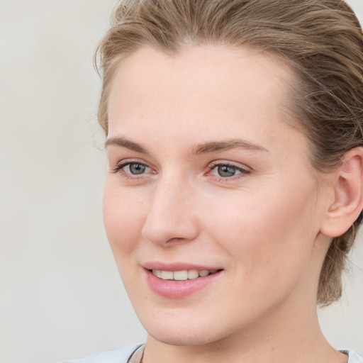 Joyful white young-adult female with medium  brown hair and blue eyes