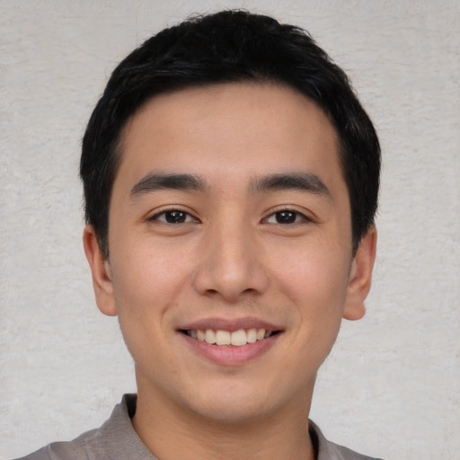 Joyful asian young-adult male with short  black hair and brown eyes