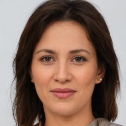 Joyful white adult female with long  brown hair and brown eyes