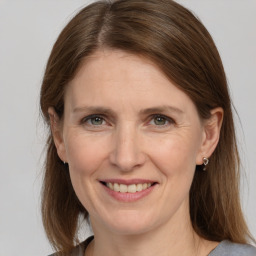 Joyful white adult female with medium  brown hair and grey eyes