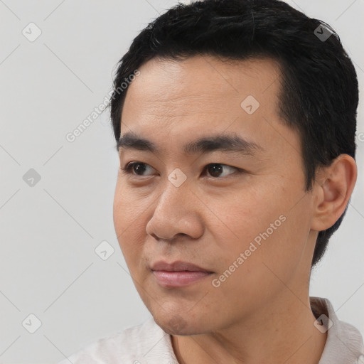 Joyful asian young-adult male with short  black hair and brown eyes