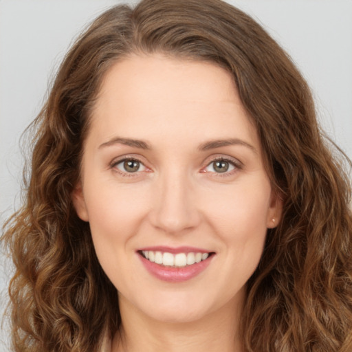 Joyful white young-adult female with long  brown hair and green eyes