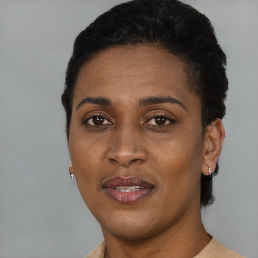 Joyful black young-adult female with short  black hair and brown eyes