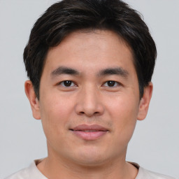 Joyful asian young-adult male with short  brown hair and brown eyes