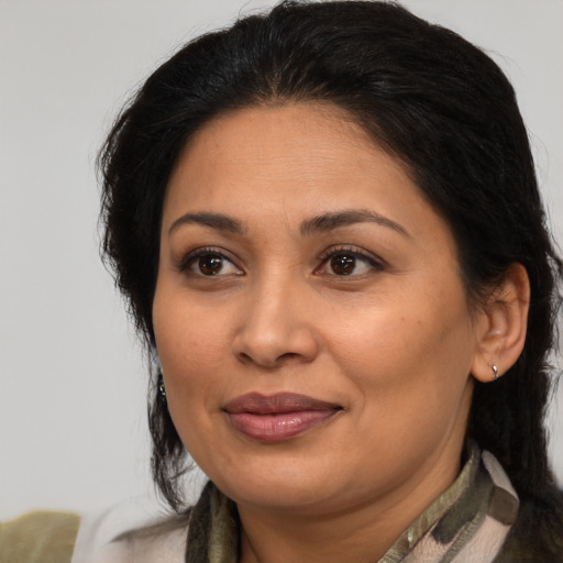 Joyful latino adult female with medium  brown hair and brown eyes