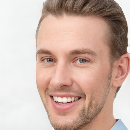 Joyful white young-adult male with short  brown hair and grey eyes