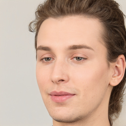 Joyful white young-adult male with long  brown hair and brown eyes