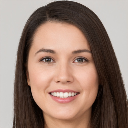 Joyful white young-adult female with long  brown hair and brown eyes