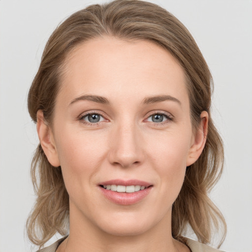 Joyful white young-adult female with medium  brown hair and grey eyes