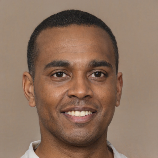 Joyful latino young-adult male with short  brown hair and brown eyes