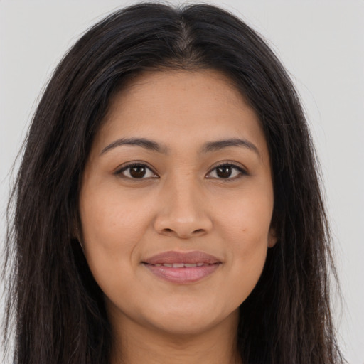 Joyful latino young-adult female with long  brown hair and brown eyes