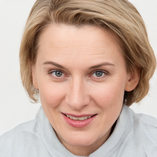 Joyful white adult female with medium  brown hair and blue eyes