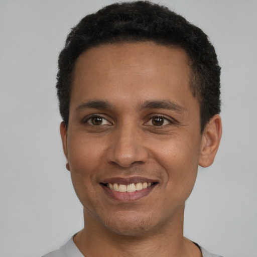 Joyful latino young-adult male with short  black hair and brown eyes