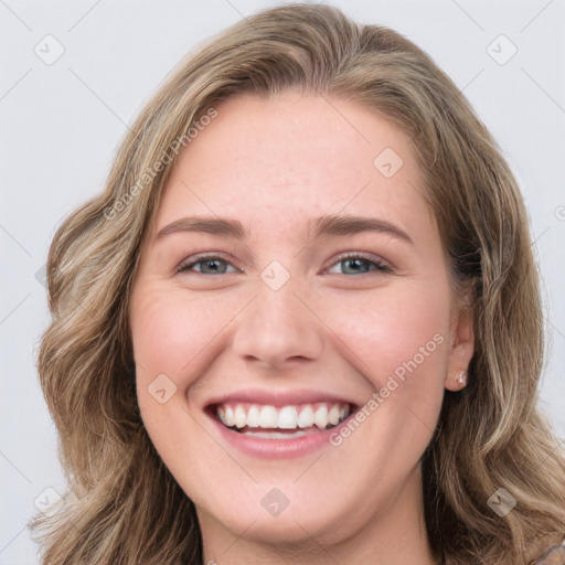 Joyful white young-adult female with long  brown hair and blue eyes