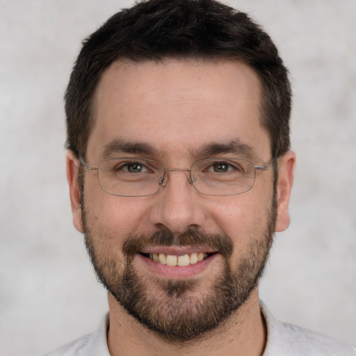 Joyful white adult male with short  black hair and brown eyes