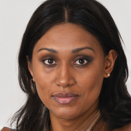 Joyful black young-adult female with long  brown hair and brown eyes