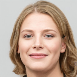 Joyful white young-adult female with long  brown hair and blue eyes