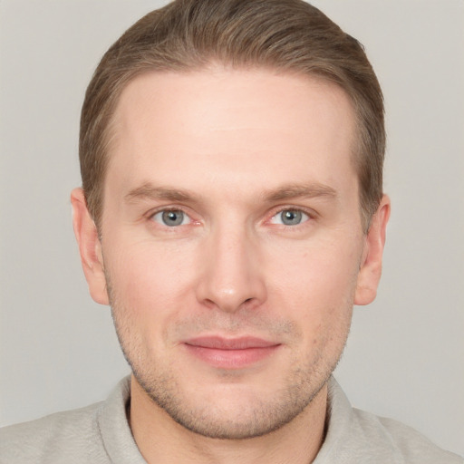 Joyful white young-adult male with short  brown hair and grey eyes