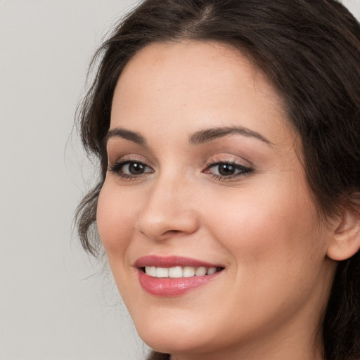 Joyful white young-adult female with long  brown hair and brown eyes