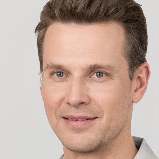 Joyful white adult male with short  brown hair and grey eyes