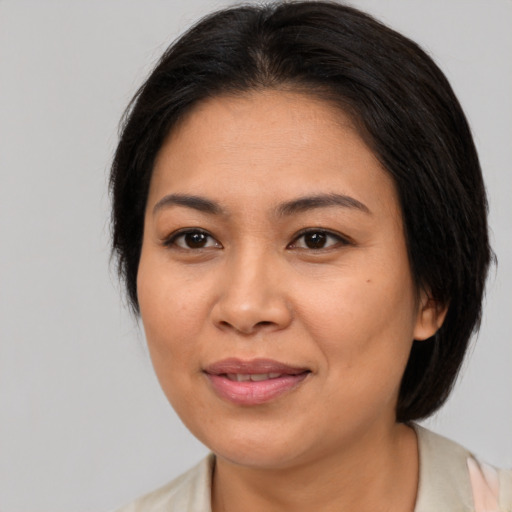 Joyful asian adult female with medium  brown hair and brown eyes