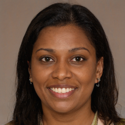 Joyful black young-adult female with long  brown hair and brown eyes