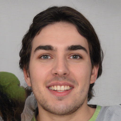 Joyful white young-adult male with medium  brown hair and brown eyes