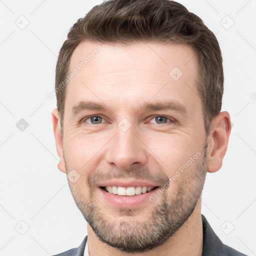 Joyful white young-adult male with short  brown hair and grey eyes