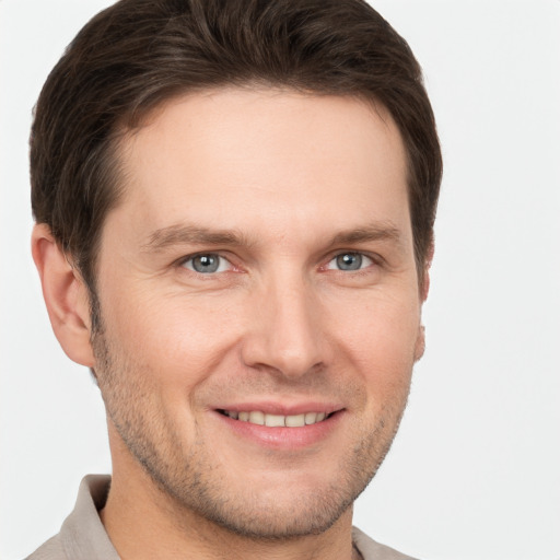 Joyful white young-adult male with short  brown hair and grey eyes