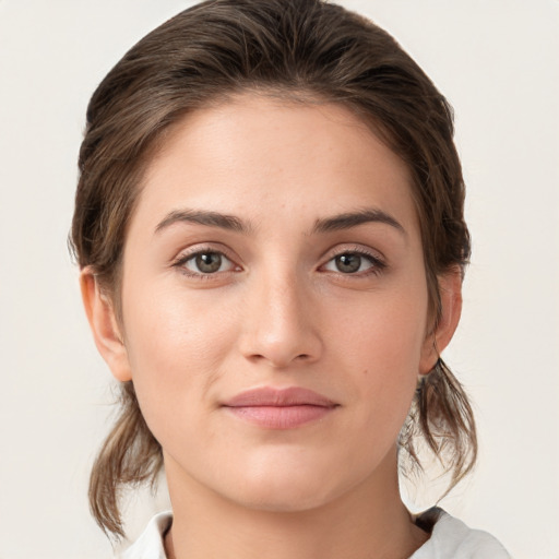 Joyful white young-adult female with medium  brown hair and grey eyes