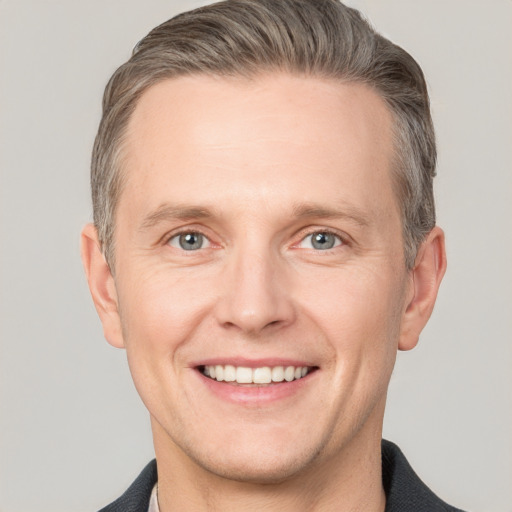 Joyful white adult male with short  brown hair and grey eyes