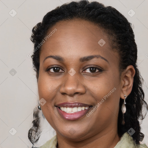 Joyful black young-adult female with long  brown hair and brown eyes