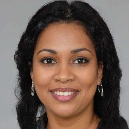 Joyful black young-adult female with long  black hair and brown eyes