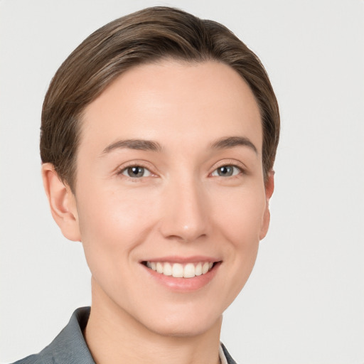 Joyful white young-adult female with short  brown hair and grey eyes