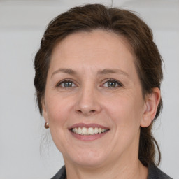 Joyful white young-adult female with medium  brown hair and grey eyes