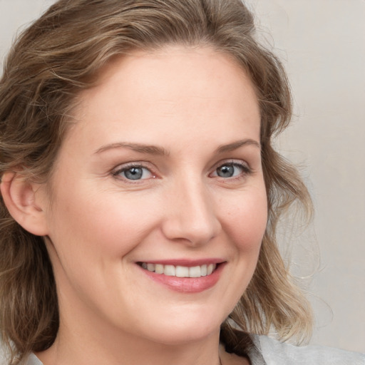 Joyful white young-adult female with medium  brown hair and blue eyes