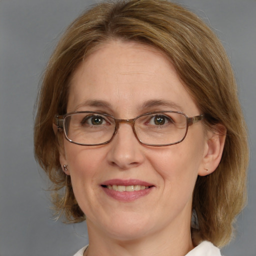 Joyful white adult female with medium  brown hair and blue eyes