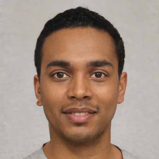 Joyful black young-adult male with short  black hair and brown eyes