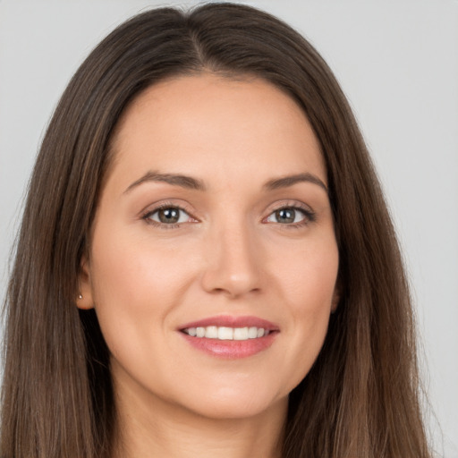 Joyful white young-adult female with long  brown hair and brown eyes