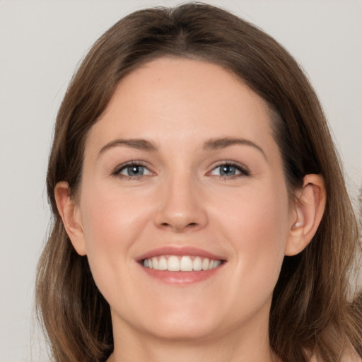 Joyful white young-adult female with long  brown hair and grey eyes