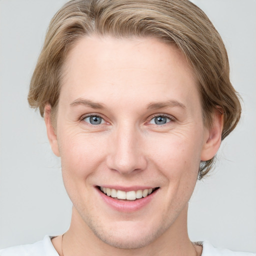 Joyful white young-adult female with short  brown hair and blue eyes